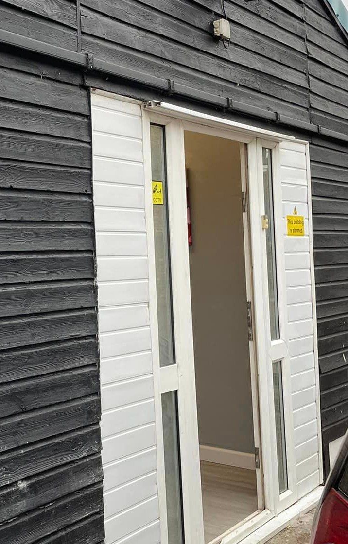 The clinic entrance: white double doors in a black weatherboard building